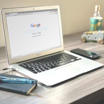 A laptop on a desk showing a page of Google search